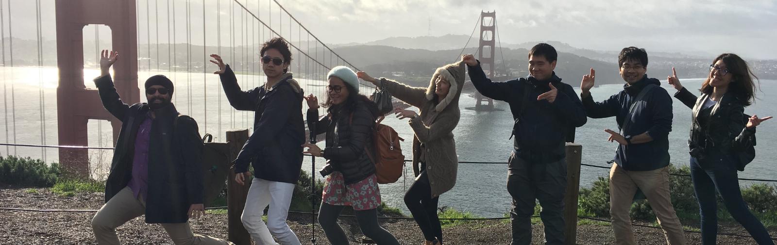 People posing next to golden gate bridge.