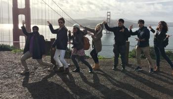 People posing next to golden gate bridge.