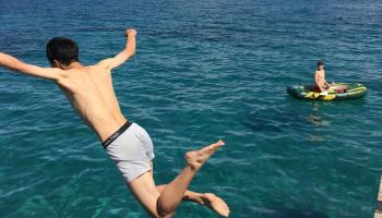 A person on vacation jumping into Lake Tahoe.