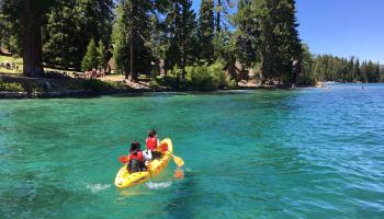 Two people riding in a tandem kayak at Lake Tahoe, Nevada.
